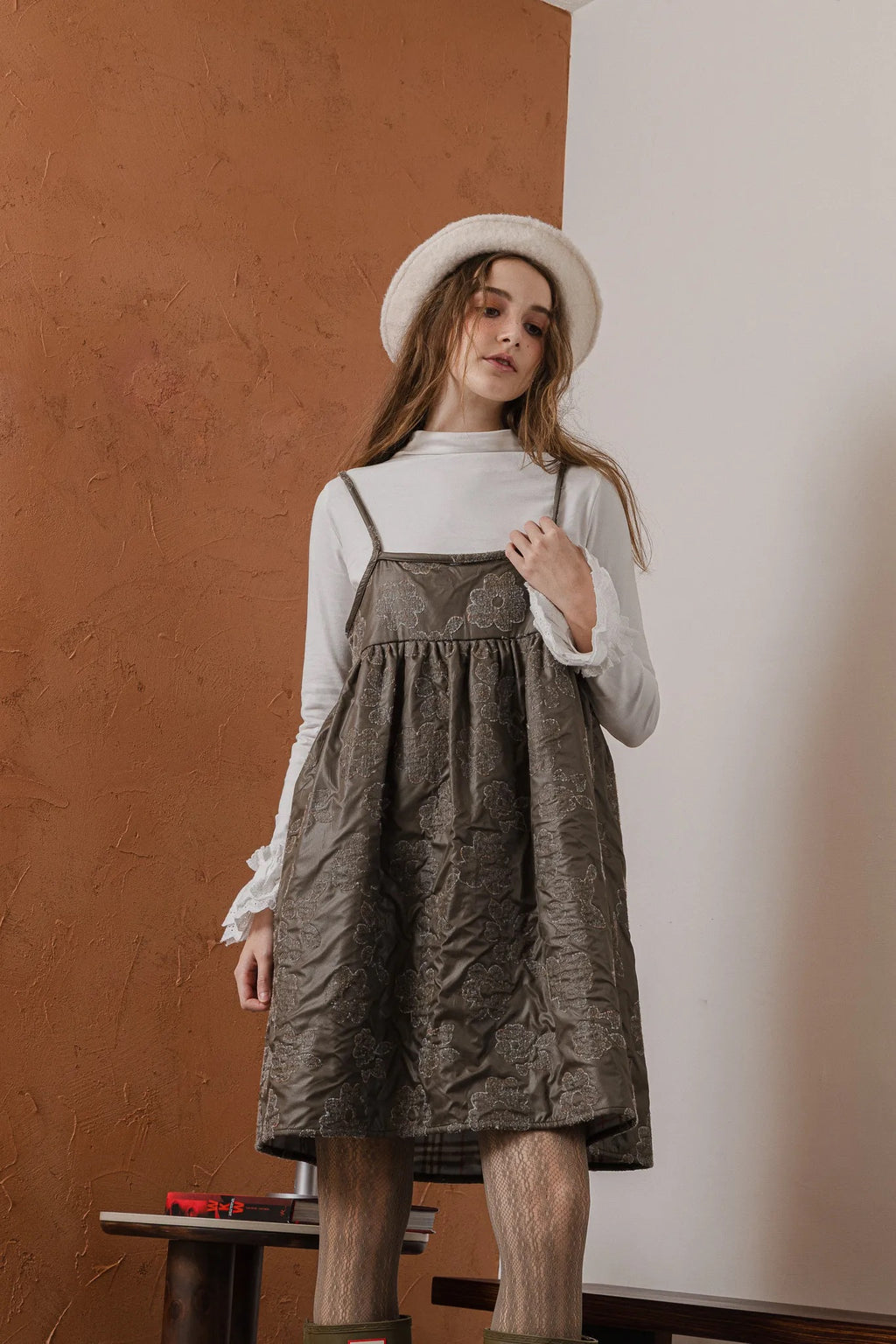 模特兒穿著羊毛花瓣細肩帶洋裝，特殊羊毛花布面料風衣質感，內裡鋪棉設計展現舒適實用的日常造型。