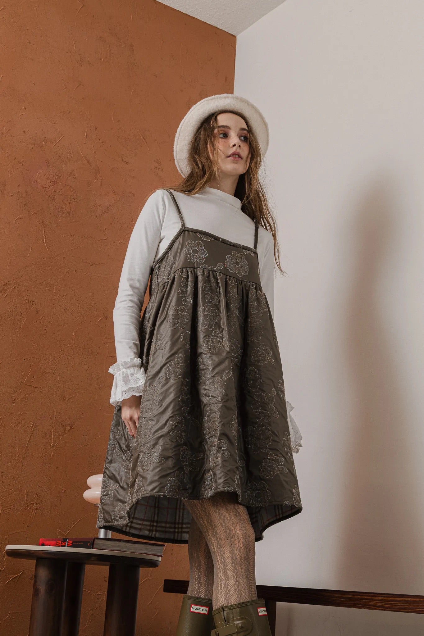 模特兒穿著羊毛花瓣細肩帶洋裝，特殊羊毛花布面料風衣質感，內裡鋪棉設計展現舒適實用的日常造型。