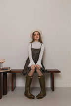 模特兒穿著羊毛花瓣細肩帶洋裝，特殊羊毛花布面料風衣質感，內裡鋪棉設計展現舒適實用的日常造型。